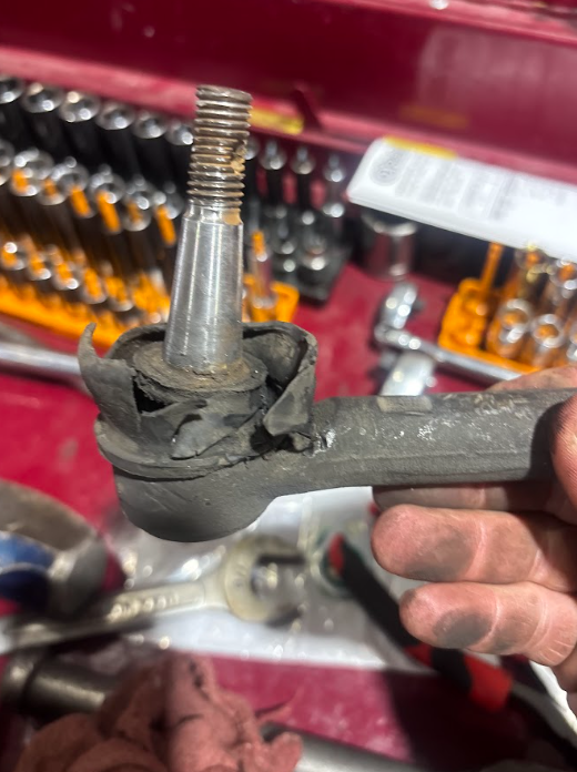 Worn tie rod end with a torn boot